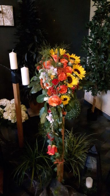 Bunte Blumenarrangements mit Sonnenblumen und grünen Pflanzen.